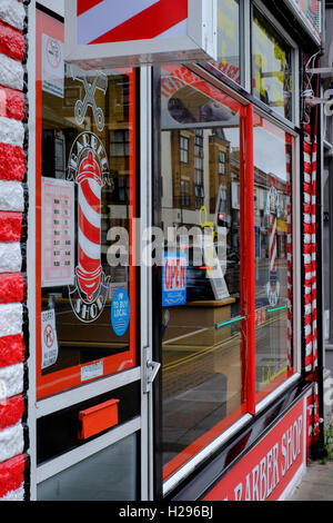 Les barbiers traditionnels avec un extérieur blanc à rayures rouges et uk Banque D'Images