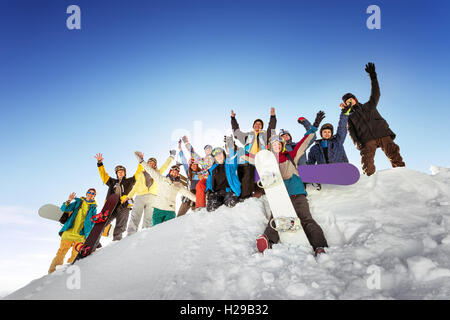 Les snowboarders posant sur fond de ciel bleu montagne Banque D'Images