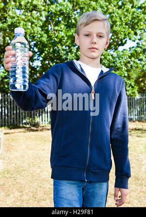 Jeune adolescent avec bouteille d'eau dans park Banque D'Images