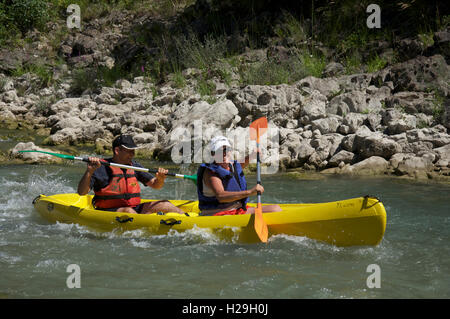 Le tourisme, les sports nautiques, les touristes. A smiling couple canoë sur le courant rapide des eaux agitées de la Drôme. Près de Saillans, la Drôme, France. Banque D'Images