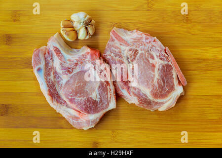 La viande fraîche : matières gras cru côtes de porc et filet d'agneau avec green stuff et piment rouge sur plaque de bois isolated over white Banque D'Images