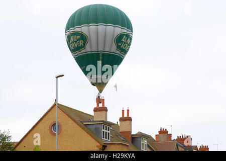 Northampton Royaume-uni Abington Park, le 18 sept 2016. Land Rover hot air ballon volant bas sur les toits. Banque D'Images