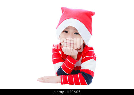 Joyeux noël boy laying and smiling in santa hat sur fond blanc Banque D'Images