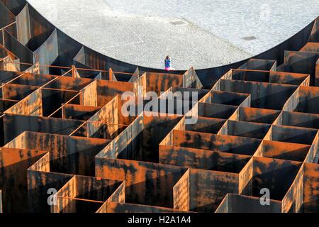 Genk, en Belgique. 26 Sep, 2016. Une fille repose sur le mur de "labyrinthe", un métal expérimental installation labyrinthe à Genk, Belgique, le 26 septembre, 2016. Avec le poids de 186 tonnes et les murs de jusqu'à cinq mètres de hauteur, le labyrinthe a été ouvert à la visite publique de juillet 2015 à septembre 2016. © Zhang Yunlong/Xinhua/Alamy Live News Banque D'Images