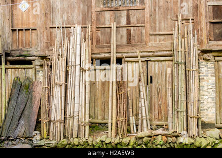 Les murs en bois de maison de village avec des tiges de bambou attachés leaning against Wall en Chine Banque D'Images