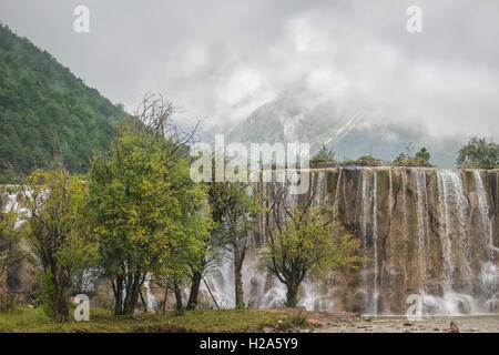 Cascade et montagnes couvertes de brouillard dans le Yunnan, Chine Banque D'Images