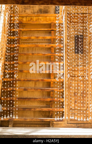 Toile de stores en perles en face de la porte et escalier en bois Banque D'Images