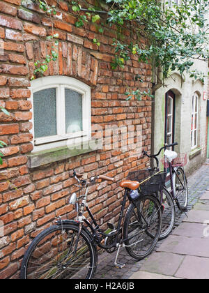 Des vélos Vintage appuyé contre un mur de briques Banque D'Images