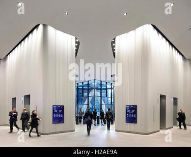 Hall d'accueil avec des barrières de sécurité et des ascenseurs. Le Gherkin, Londres, Royaume-Uni. Architecte : Foster  + Partners, 2004. Banque D'Images