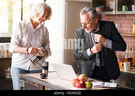 Belle femme âgée pouring coffee à son mari Banque D'Images