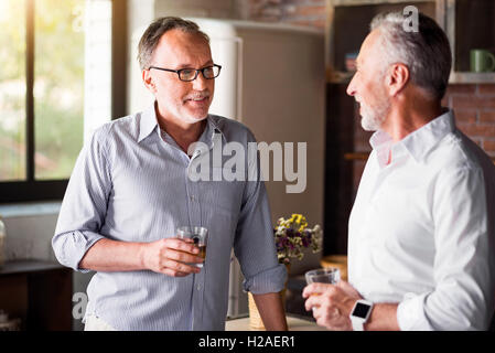 Ambiance de vieux amis de boire du whisky dans la cuisine Banque D'Images