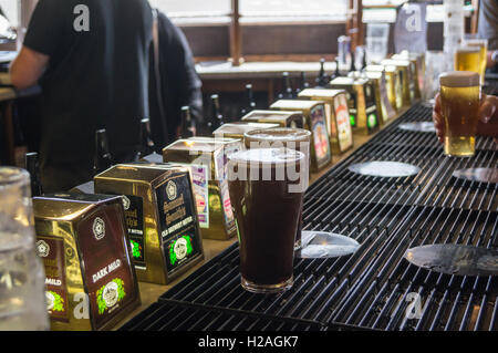 Pintes de stout sur la barre à Sam Smith Sinclair's Oyster Bar, approche de la Cathédrale, Manchester, Angleterre Banque D'Images