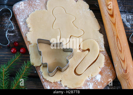 La cuisson de cookies de Noël - la pâte sur la table, d'un emporte-pièce et les cookies. Nouvelle année. Noël Banque D'Images