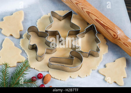 La cuisson de cookies de Noël - la pâte sur la table, d'un emporte-pièce et les cookies. Nouvelle année. Noël Banque D'Images