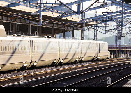 Le Japon. Fukuyama. Afficher le long de la n700 series, Shinkansen bullet train en gare, coucher de soleil très fort le blanchiment de la couleur du train. Banque D'Images