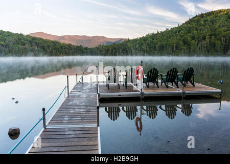 Chaises Adirondack sur le dock de Heart Lake sur un matin brumeux dans la région des hauts sommets des Adirondacks près de Lake Placid, NY Banque D'Images