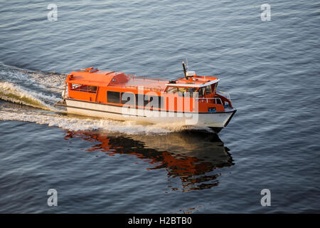 Un petit canot de sauvetage accompagne l'océan ferry pour naviguer entre les îles Banque D'Images