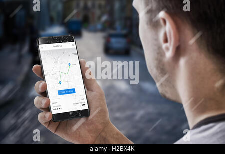 Recherche de l'utilisateur pilote le plus proche sur l'application mobile. Rue de la ville en arrière-plan. L'affichage indique la voie de circulation. Banque D'Images