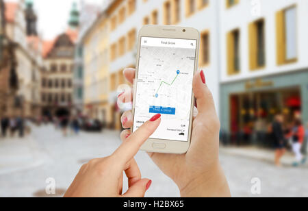 Trouver dur application pour smartphone en main femme. Plan de ville, d'un sentier, chauffeur et voiture sur l'écran du téléphone. Banque D'Images