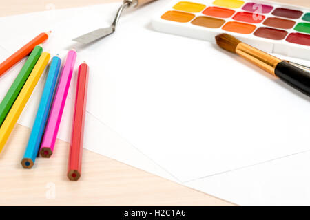 Crayons de couleurs et aquarelles sont autour de la feuille blanche Banque D'Images