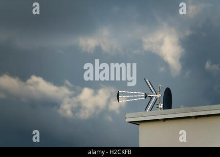 Chambre extérieur avec antenne sur le toit et nuages dans le ciel avec l'exemplaire de l'espace. Banque D'Images