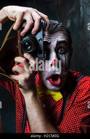 Le clown effrayant et une caméra sur dack arrière-plan. Concept d'Halloween Banque D'Images