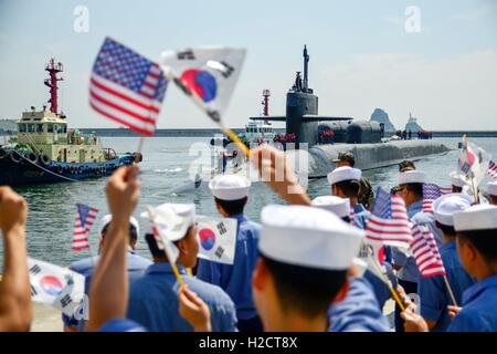 Les marins américains et coréens agitent des drapeaux et applaudir, se félicitant de la NSU de classe Ohio Nuclear-powered balistique de la flotte de sous-marins lance-missiles USS Ohio comme il arrive à la base de la flotte de la République de Corée pour un port régulier, 13 juillet 2016 Visite à Busan, Corée. Banque D'Images