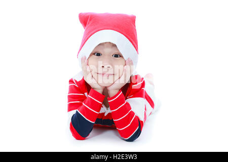 Joyeux noël boy laying and smiling in santa hat sur fond blanc Banque D'Images