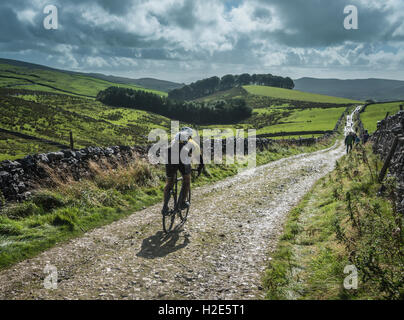 Un cavalier en ordre décroissant Penyghent dans les 3 pics 2016 cyclocross, Yorkshire Dales, au Royaume-Uni. Banque D'Images