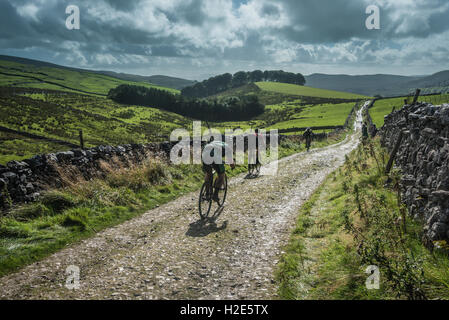 Un cavalier en ordre décroissant Penyghent dans les 3 pics 2016 cyclocross, Yorkshire Dales, au Royaume-Uni. Banque D'Images