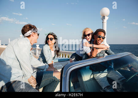 Groupe multiethnique de jeunes heureux de parler et s'amuser en cabriolet Banque D'Images