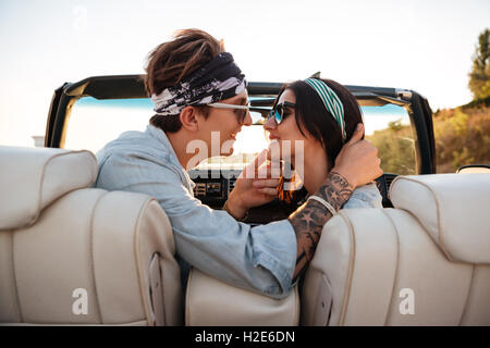 Happy young couple kissing in cabriolet en été Banque D'Images