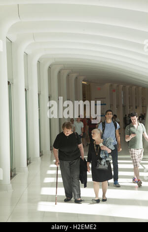 Les visiteurs et clients dans l'Oculus Mall au World Trade Centre à pied à travers l'un des couloirs donnant sur le hall central d'un côté et les magasins de l'autre. La ville de New York. Banque D'Images