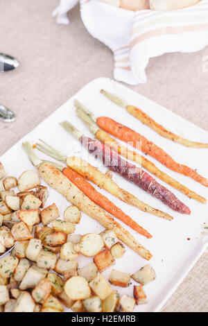 Portrait d'une assiette de carottes et pommes de terre grillées sur une table à la garden party. Banque D'Images