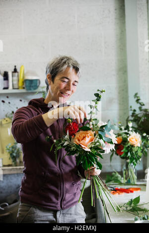 Des arrangements de fleurs biologiques. Une femme de la création d'un bouquet attachés à la main. Banque D'Images