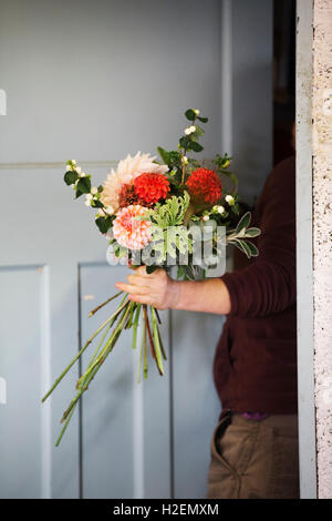 Des arrangements de fleurs biologiques. Une femme de la création d'un bouquet attachés à la main. Banque D'Images