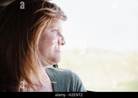 Femme dans une voiture sur un voyage sur la route, regarder par la fenêtre. Banque D'Images