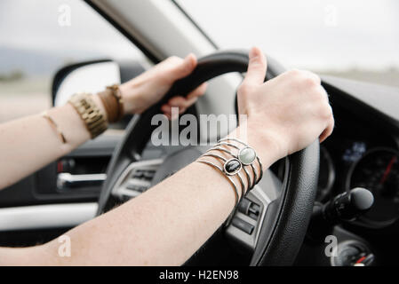 Une femme avec ses mains sur le volant. Banque D'Images