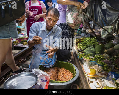 Samut Songkhram, Samut Songkhram, Thaïlande. 27 Sep, 2016. Un homme vend des crevettes grillées sur le marché de la gare Samut Songkhram. Le train de l'Baen Laem à Samut Songkhram (Mae Khlong) récemment repris du service. La piste de 33 kilomètres a été fermée pour réparation pendant près d'un an. Dans Samut Songkhram, le train passe sur le marché. Tirer sur leurs stands des fournisseurs à l'écart et les gens sortir de la façon que le train passe à travers le marché. C'est l'une des plus célèbres stations de train en Thaïlande et est devenu une importante attraction touristique dans la communauté. (Crédit Image : © Jack Banque D'Images