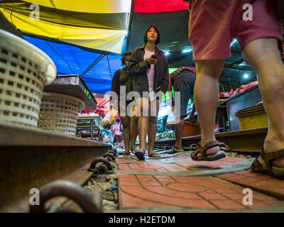 Samut Songkhram, Samut Songkhram, Thaïlande. 27 Sep, 2016. Les gens marchent le long de l'emprise de chemin de fer dans le marché de la gare Samut Songkhram. Le train de l'Baen Laem à Samut Songkhram (Mae Khlong) récemment repris du service. La piste de 33 kilomètres a été fermée pour réparation pendant près d'un an. Dans Samut Songkhram, le train passe sur le marché. Tirer sur leurs stands des fournisseurs à l'écart et les gens sortir de la façon que le train passe à travers le marché. C'est l'une des plus célèbres stations de train en Thaïlande et est devenu une importante attraction touristique dans la communauté. (Cre Banque D'Images