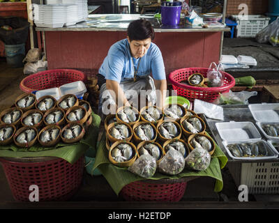 Samut Songkhram, Samut Songkhram, Thaïlande. 27 Sep, 2016. Un vendeur met en place son stand vente de poissons et fruits de mer sur le marché de la gare Samut Songkhram. Le train de l'Baen Laem à Samut Songkhram (Mae Khlong) récemment repris du service. La piste de 33 kilomètres a été fermée pour réparation pendant près d'un an. Dans Samut Songkhram, le train passe sur le marché. Tirer sur leurs stands des fournisseurs à l'écart et les gens sortir de la façon que le train passe à travers le marché. C'est l'une des plus célèbres stations de train en Thaïlande et est devenu une importante attraction touristique dans la communication Banque D'Images