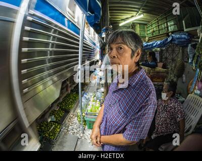 Samut Songkhram, Samut Songkhram, Thaïlande. 27 Sep, 2016. Une femme qui travaillent dans le marché des montres Samut Songkhram gare un train entre en gare. Le train de l'Baen Laem à Samut Songkhram (Mae Khlong) récemment repris du service. La piste de 33 kilomètres a été fermée pour réparation pendant près d'un an. Dans Samut Songkhram, le train passe sur le marché. Tirer sur leurs stands des fournisseurs à l'écart et les gens sortir de la façon que le train passe à travers le marché. C'est l'une des plus célèbres stations de train en Thaïlande et est devenu une importante attraction touristique dans la pers Banque D'Images