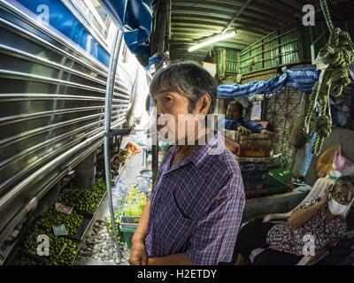 Samut Songkhram, Samut Songkhram, Thaïlande. 27 Sep, 2016. Une femme qui travaillent dans le marché des montres Samut Songkhram gare un train entre en gare. Le train de l'Baen Laem à Samut Songkhram (Mae Khlong) récemment repris du service. La piste de 33 kilomètres a été fermée pour réparation pendant près d'un an. Dans Samut Songkhram, le train passe sur le marché. Tirer sur leurs stands des fournisseurs à l'écart et les gens sortir de la façon que le train passe à travers le marché. C'est l'une des plus célèbres stations de train en Thaïlande et est devenu une importante attraction touristique dans la pers Banque D'Images