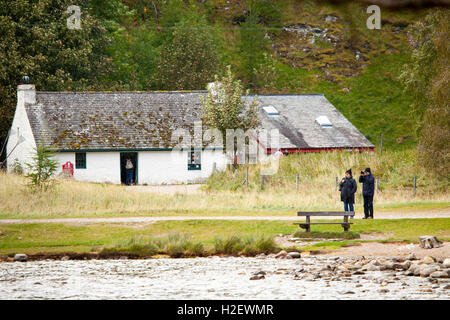 Deux visiteurs au cours de clôture de l'automne chaud comme ils prennent des photos de Loch an Eilein des rives du Loch Banque D'Images