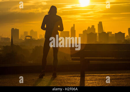 Primrose Hill, Londres, le 28 octobre 2016. Météo France : une femme prend une pause dans sa course sur Primrose Hill comme le soleil se lève sur l'horizon de Londres. Crédit : Paul Davey/Alamy Live News Banque D'Images