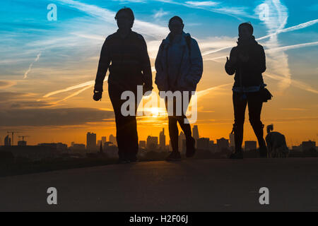 Primrose Hill, Londres, le 28 octobre 2016. Météo France : trois amis à pied leurs chiens sur Primrose Hill comme le soleil se lève sur l'horizon de Londres. Crédit : Paul Davey/Alamy Live News Banque D'Images