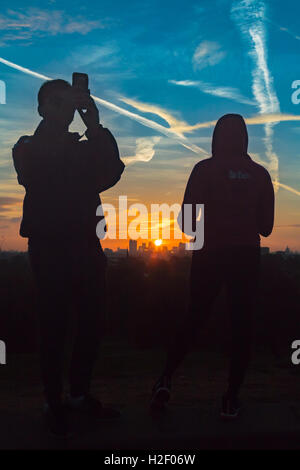 Primrose Hill, Londres, le 28 octobre 2016. Météo France : un couple de prendre des photos et regarder le lever du soleil sur les toits de la ville comme l'aube sur Londres. Crédit : Paul Davey/Alamy Live News Banque D'Images