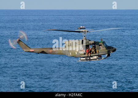 Vol stationnaire en hélicoptère. Plongeur se préparant à sauter d'une armée de l'air italienne ou Aeronautica Militare Italiana Agusta-Bell AB212 pendant une simulation de sauvetage Banque D'Images