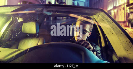 Jeune homme fatigué au volant de sa propre voiture Banque D'Images