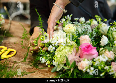 Une femme travaillant sur un arrangement floral, un fleuriste. Banque D'Images